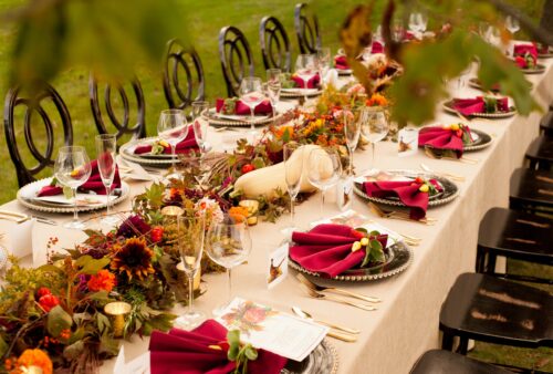Long reception table with burgundy napkins and autumn floral runner at The Estate at Sunset Farm