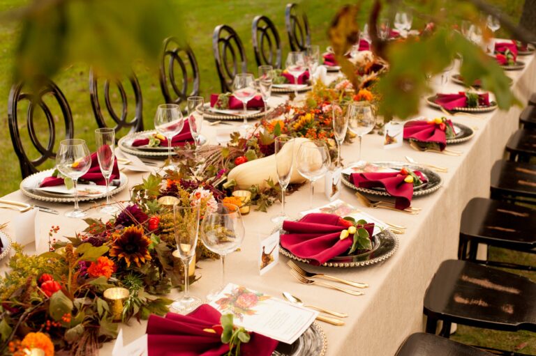 Long reception table with burgundy napkins and autumn floral runner at The Estate at Sunset Farm
